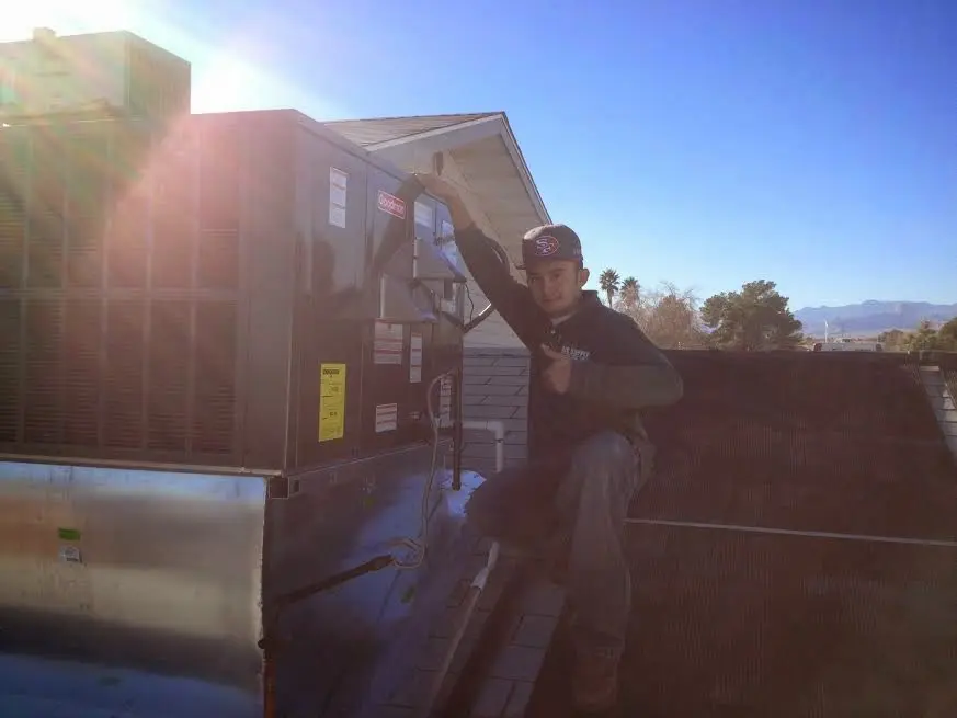 HVAC technician performing HVAC Inspection on a rooftop unit in Salisbury